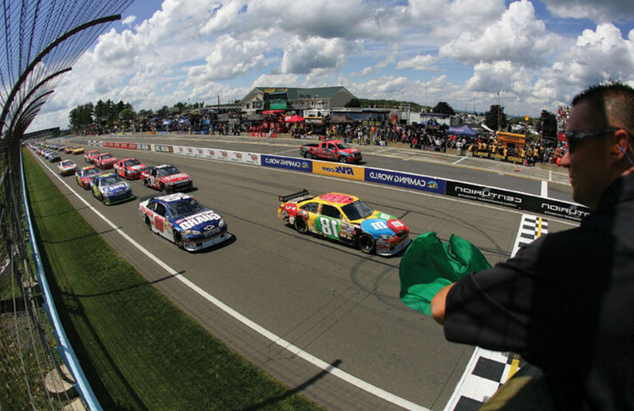 Cars race around the Watkins Glen Motor Speedway track